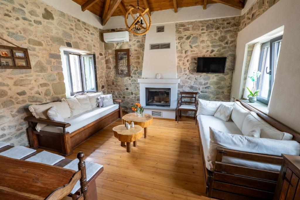 a living room with two couches and a fireplace at Doukas Village House in Gávros