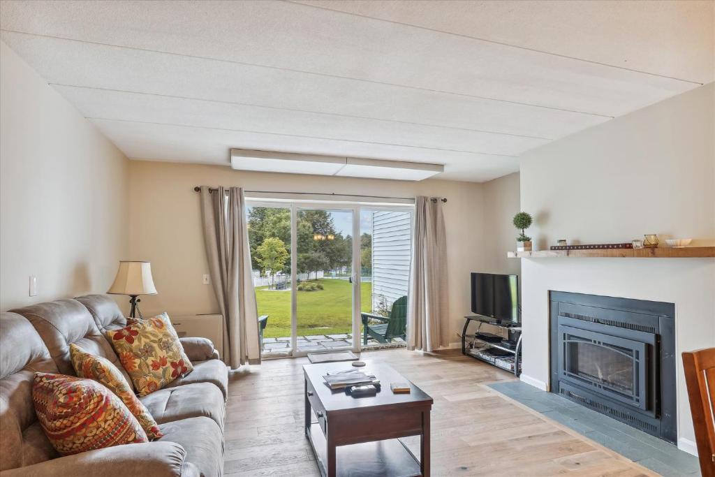 a living room with a couch and a fireplace at Lodge Condo 26 in Stowe
