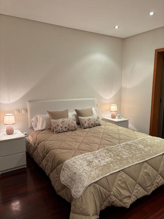 EstelaにあるCasa Gomesのベッドルーム1室(大型ベッド1台、ランプ2つ付)