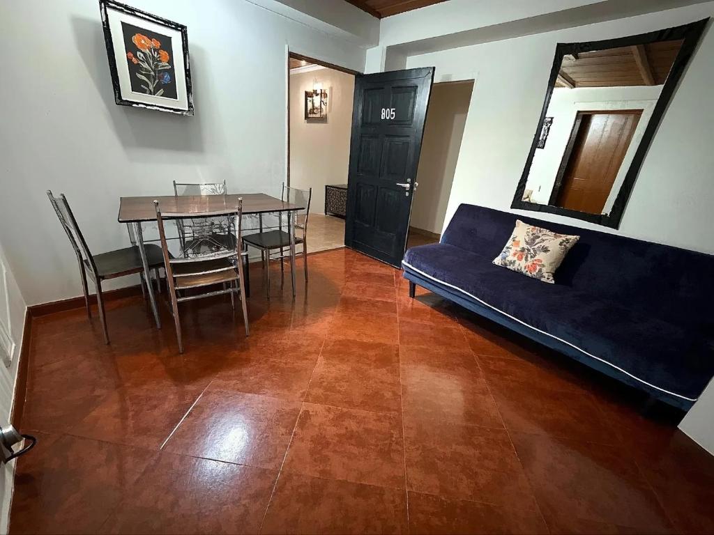 uma sala de estar com um sofá azul e uma mesa em Aparta Suite Torre De Prado 305 em Medellín