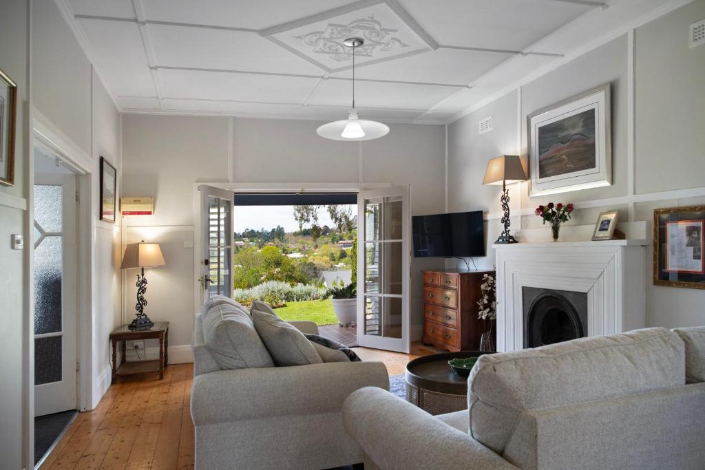 a living room with two couches and a fireplace at Churchills - outstanding views over Daylesford in Daylesford