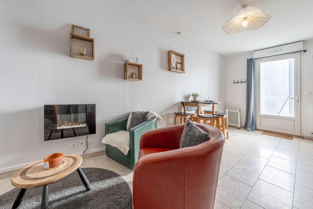 a living room with a couch and a chair at Duplex L'atelier Cosy en plein centre de Mordelles in Mordelles