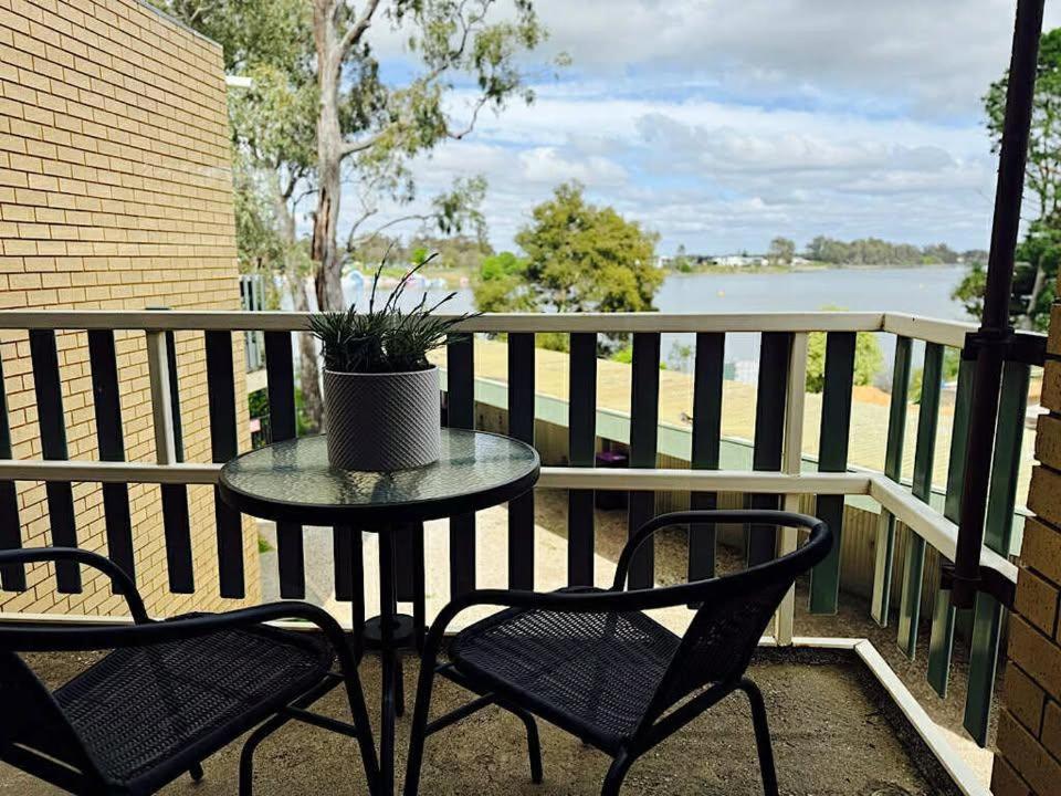 a table and chairs on a balcony with a view of the water at Young unit4 On the Lake in Nagambie