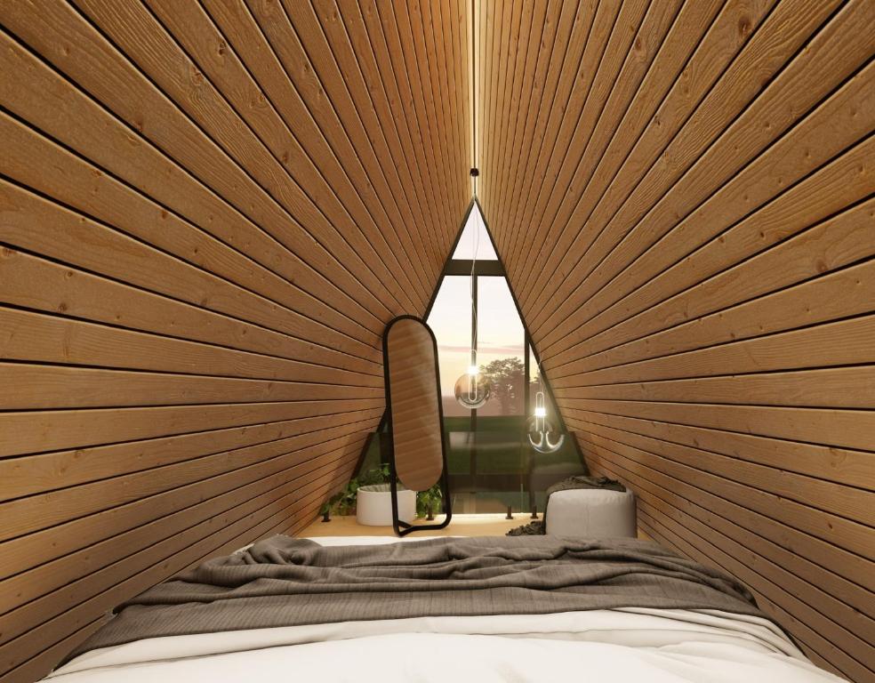 a bedroom with wooden walls and a bed with a window at Cabanas Farol in Pântano Grande