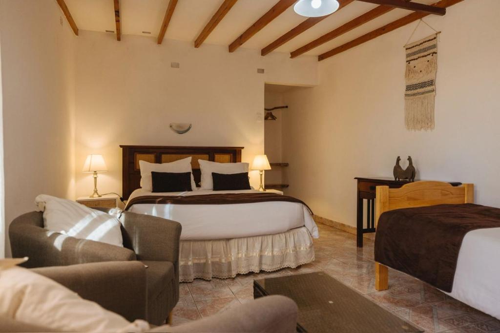 a hotel room with two beds and a couch at Lodge Don Julio in San Pedro de Atacama