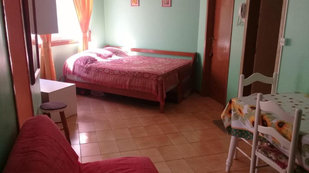 um quarto com uma cama, uma mesa e uma cadeira em Great place for summer near the sea, downtown em Capão da Canoa