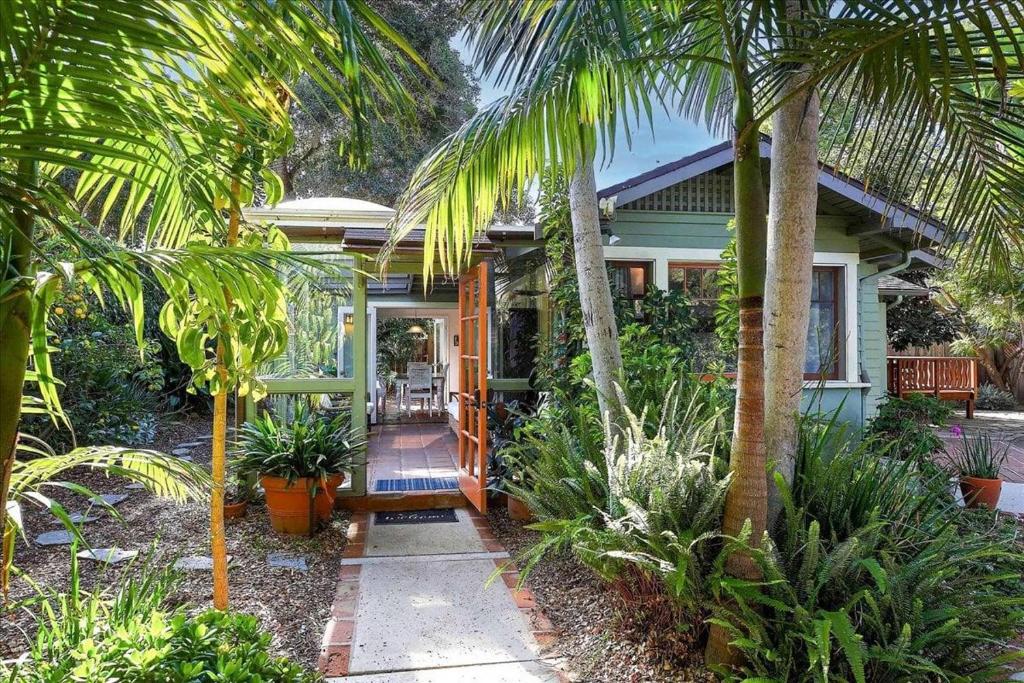 a house with palm trees in front of it at Hammonds Beach Haven in Santa Barbara