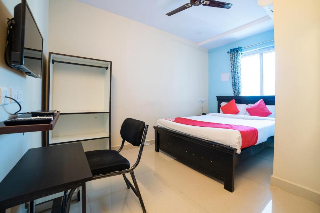 une chambre avec un lit, un bureau et une chaise dans l'établissement Hotel Blue House, à Hyderabad