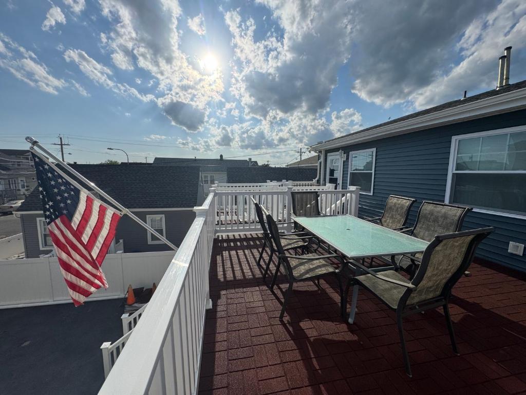 a table and chairs on a porch with an american flag at Shore Oasis in Seaside Heights
