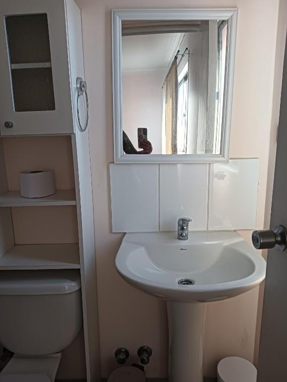 a bathroom with a sink and a mirror and a toilet at Casa Acquarella in Viña del Mar
