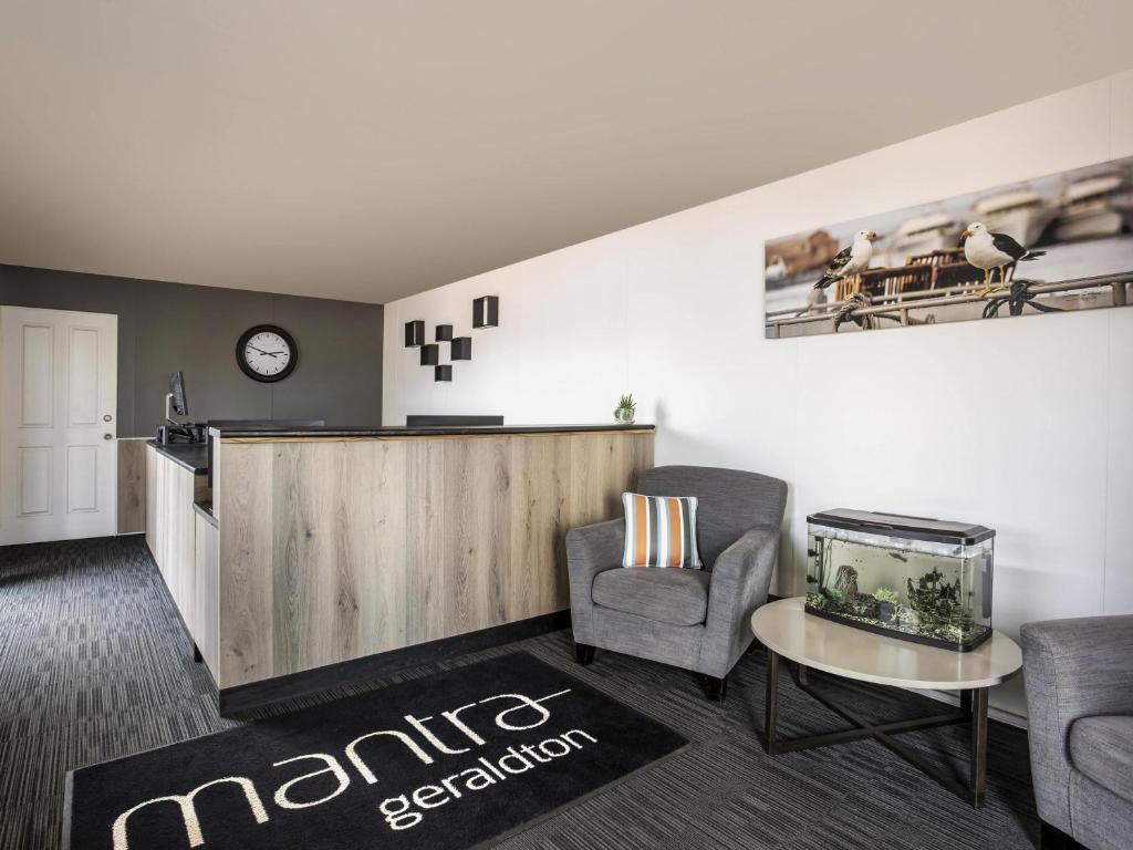 a living room with two chairs and a fish tank at Mantra Geraldton in Geraldton