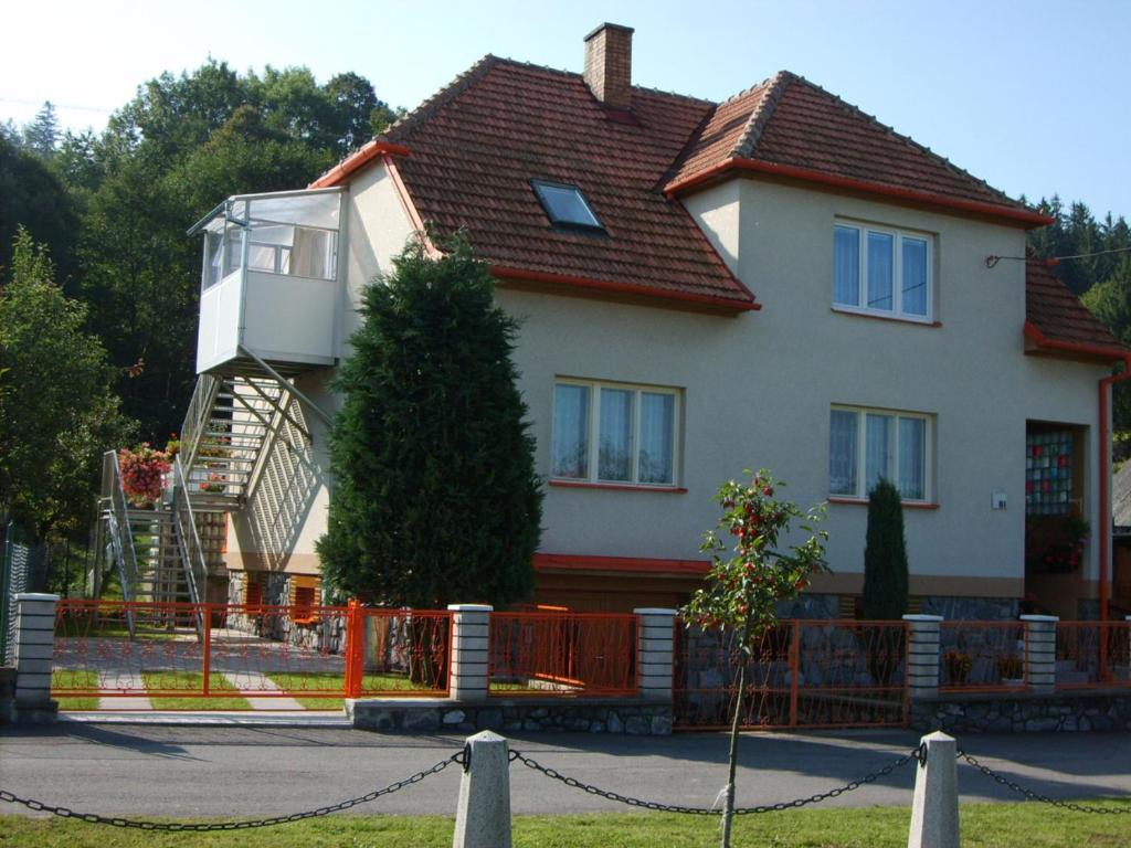 una casa grande con un árbol delante en Apartmán Eva en Crhov