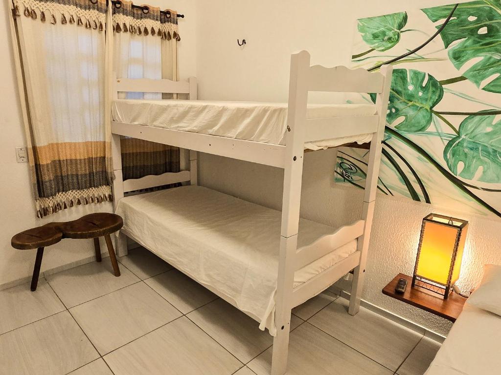 two bunk beds in a room with a table at Pousada Viva Praia in Paracuru