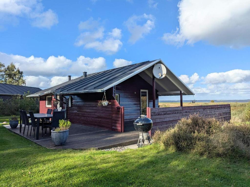 a cabin with a table and a grill on a deck at 6 person holiday home in Højslev-By Traum in Bøstrup
