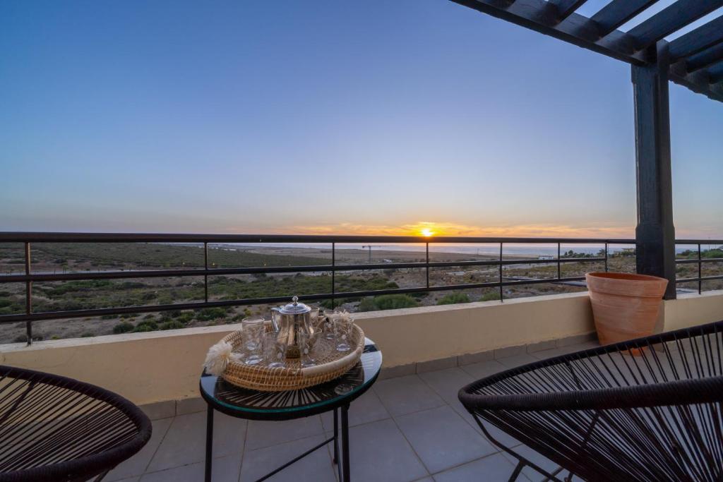 a balcony with chairs and a table with a view of the ocean at Ocean Dream - Spacious Duplex with Ocean View, Astonishing Sunset - 4 Bedrooms with Balcony - WIFI, IPTV in Tangier