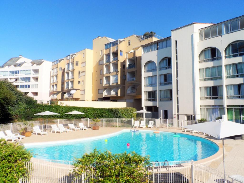 une piscine devant certains immeubles d'habitation dans l'établissement Résidence New Rochelle, à La Rochelle