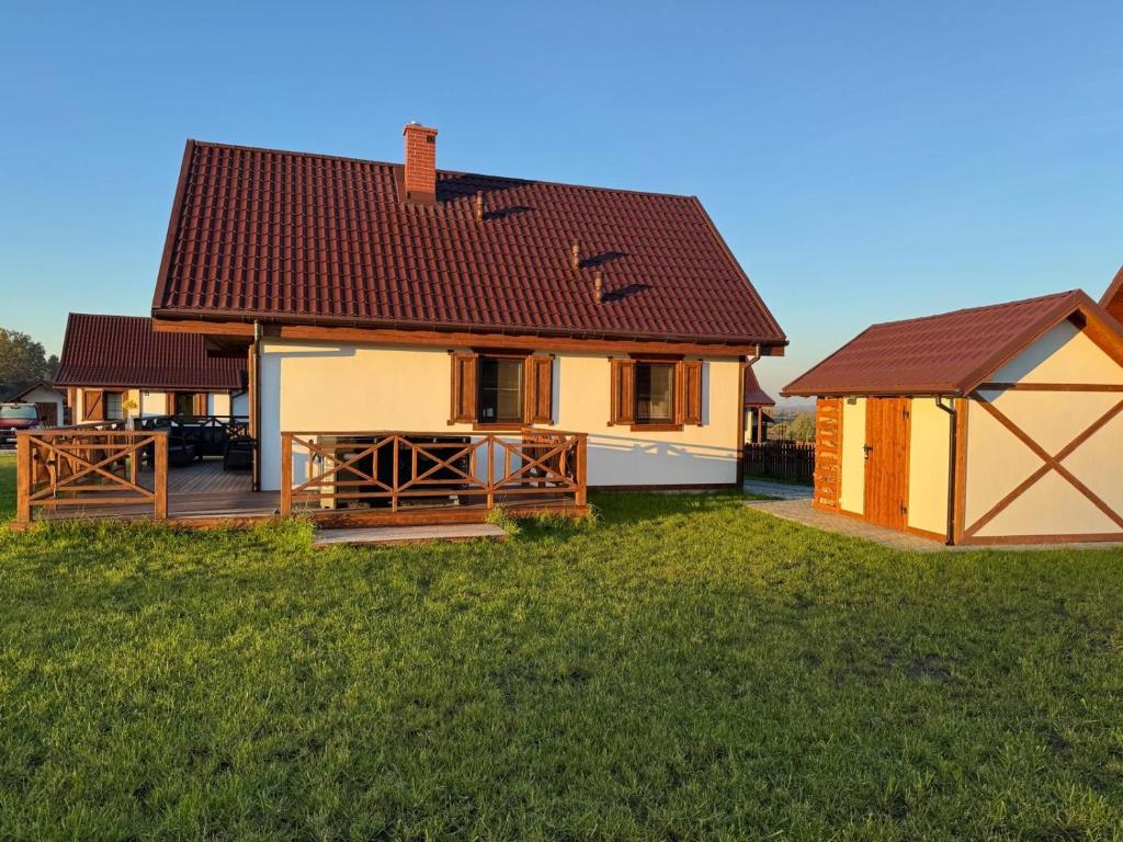 a house with a deck and a gazebo at Warmia Domek Bukowy in Woryty