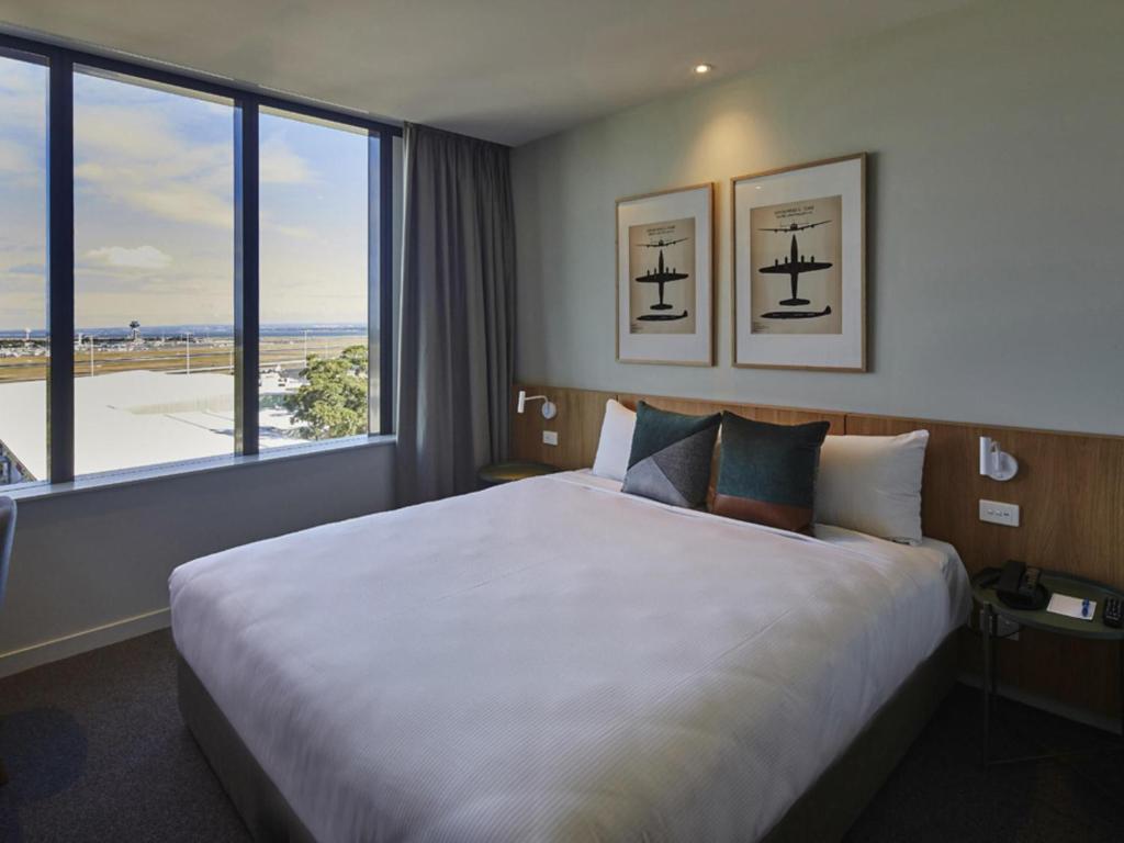 a hotel room with a large bed with a large window at Mantra on Sydney Airport in Sydney