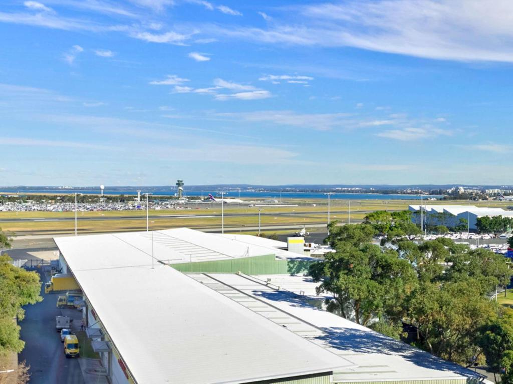 an airport with a large building and a runway at Mantra on Sydney Airport in Sydney
