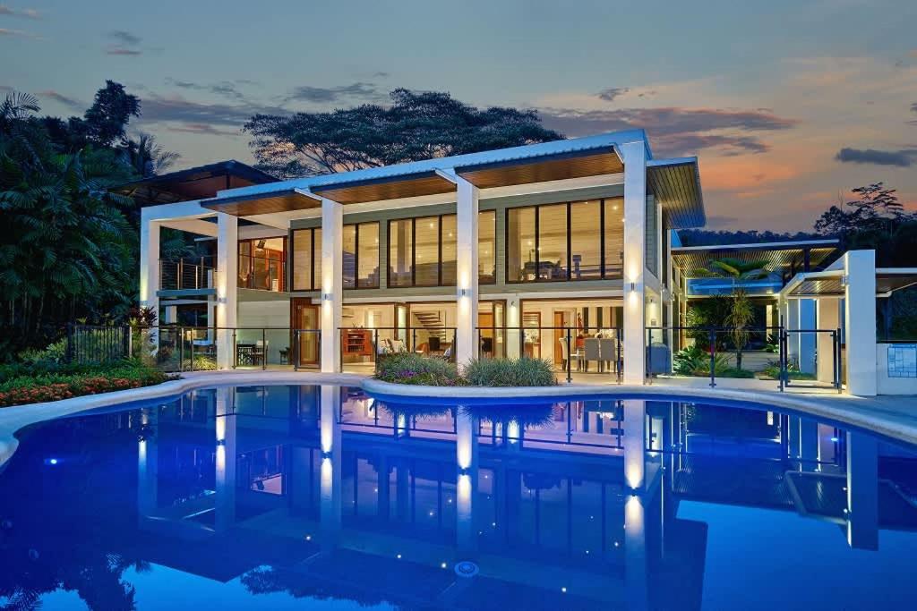 a house with a pool in front of it at Ulysses Rainforest Retreat in Mossman