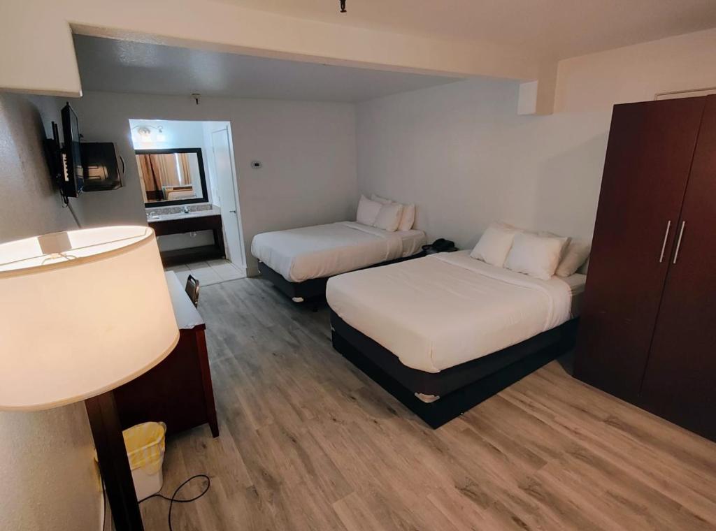 a hotel room with two beds and a television at Rancho Cordova Inn in Rancho Cordova