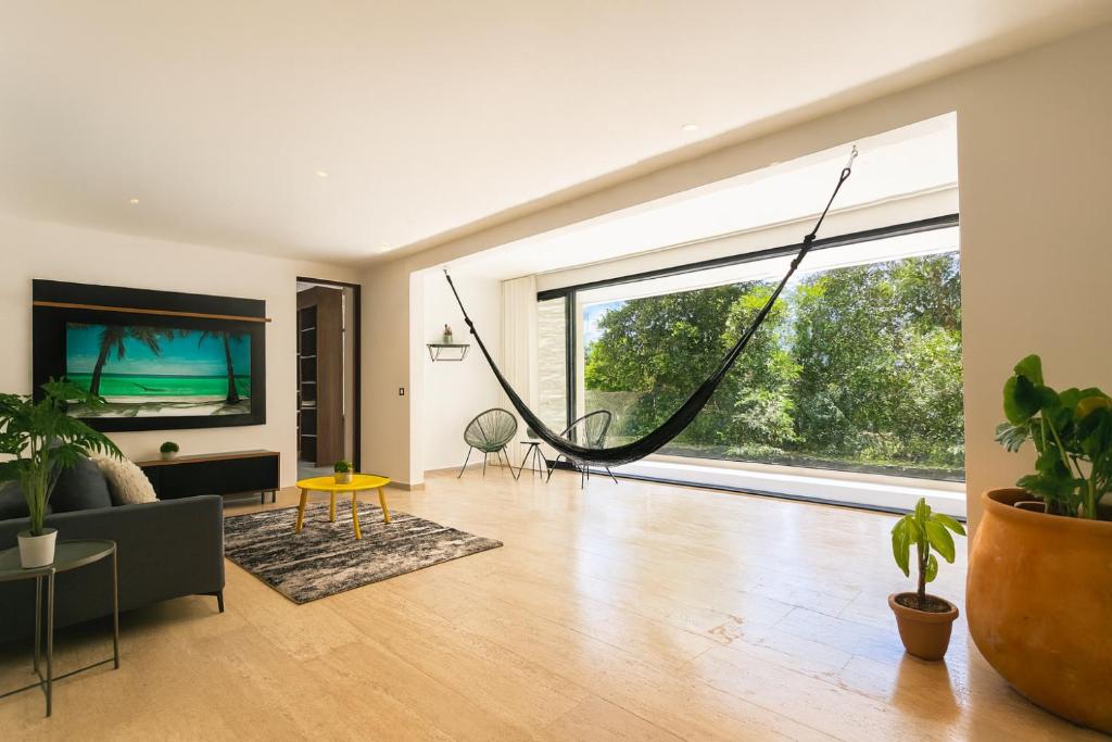 a living room with a hammock in the middle at Puerto Aventuras Private Terrace and Golf View in Puerto Aventuras