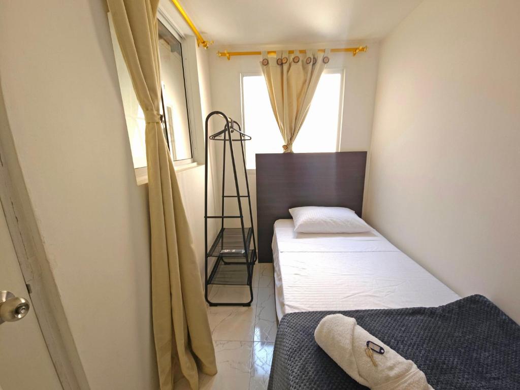 a small room with two beds and a window at Casa de Huéspedes Colibrí in Envigado