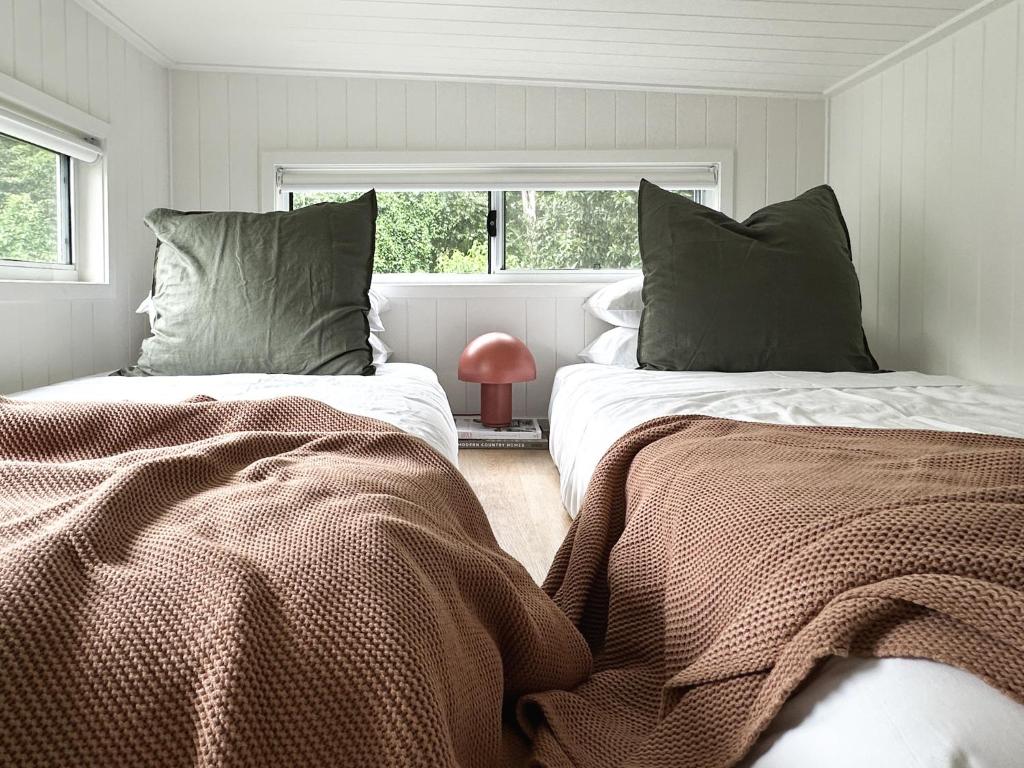 Un dormitorio con dos camas y una ventana. en Atherton Tiny - Retreat with Fire Pit, en Atherton