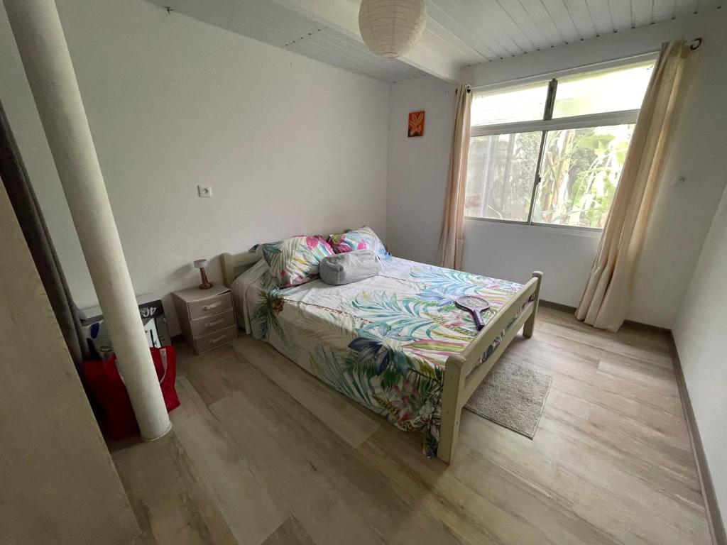 a small bedroom with a bed and a window at Hotu's Bungalow in Papeete
