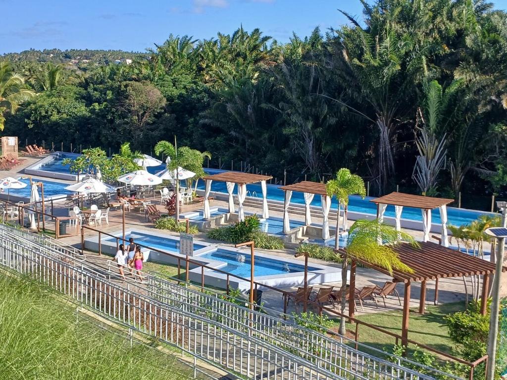 einen Pool in einem Resort mit Leuten, die ihn umlaufen in der Unterkunft Apartamento com jardim em condomínio resort in Parnamirim