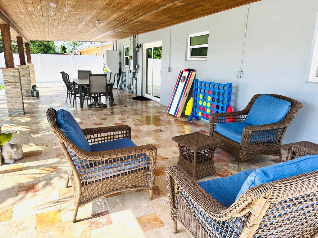 a patio with wicker chairs and a table at Family-Ready 3 BDR Oasis Near Pompano Beach in Pompano Beach