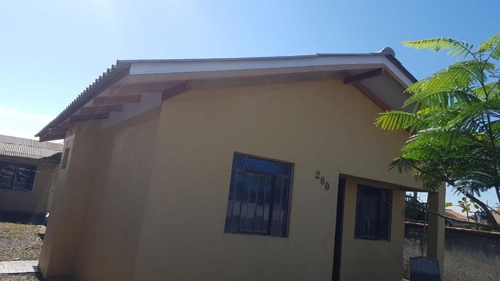 a small white house with a roof at Pousada da Lu in São Francisco do Sul