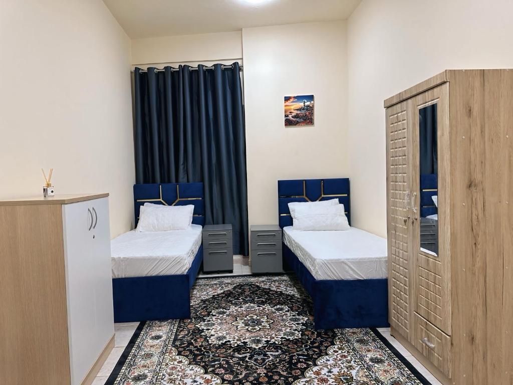 a small room with two beds and a cabinet at Chill Studio apartments Al rigga Dubai in Dubai