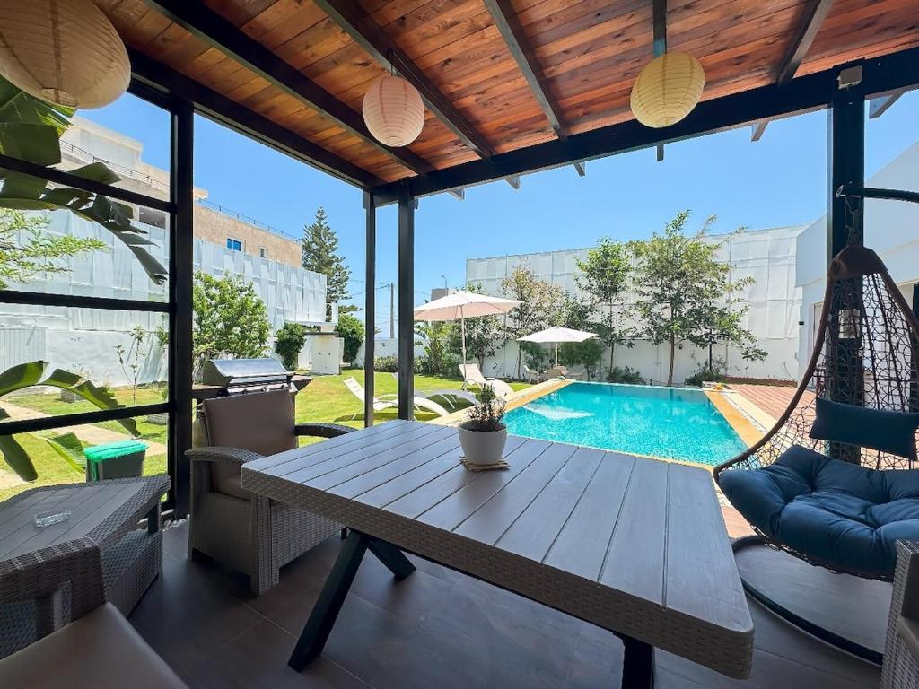 a patio with a table and chairs and a pool at Dar Aissa in El Maamoura