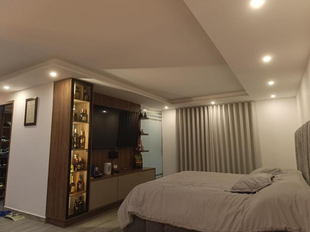 Un dormitorio con una cama y una estantería. en Penthouse with Jacuzzi in Guarne, en Guarne