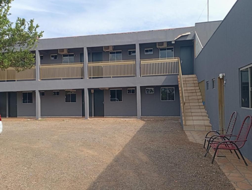 een gebouw met 2 stoelen en een balkon. bij Hotel Indubrasil Campo Grande LDTA in Campo Grande