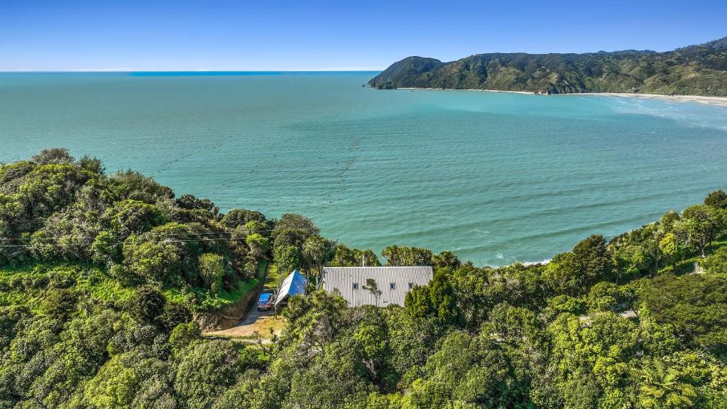 an aerial view of a house on a hill next to the ocean at The Gatehouse - Tata Headlands in Tata Beach