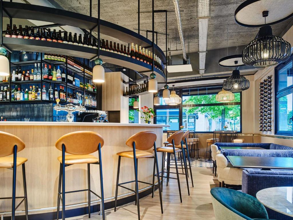 eine Bar in einem Restaurant mit Stühlen und Tischen in der Unterkunft Mercure Paris Nanterre in Nanterre