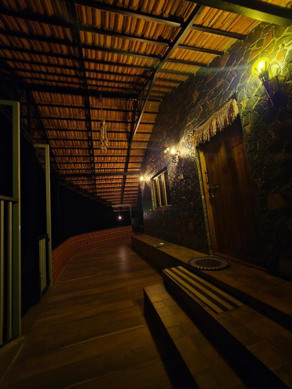 a room with a hallway with a wooden floor and a door at Naad Alaya Estate Stay in Siddapur