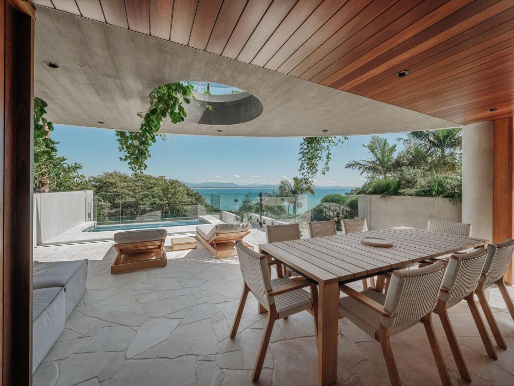una sala da pranzo con tavolo e sedie in legno di Este South a Byron Bay