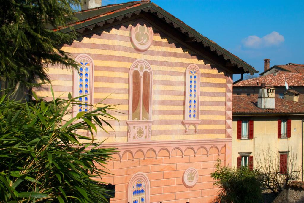 un grand bâtiment rose avec une horloge. dans l'établissement Palazzo Rivola, à Bergame