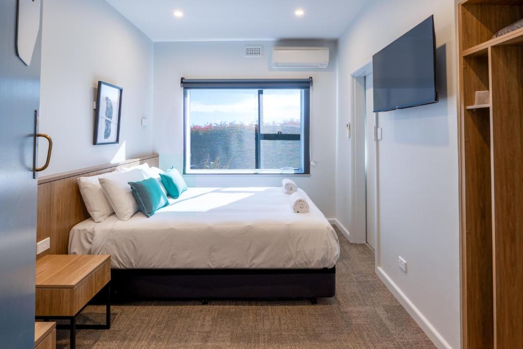 a bedroom with a large bed and a window at Claremont Hotel in Claremont