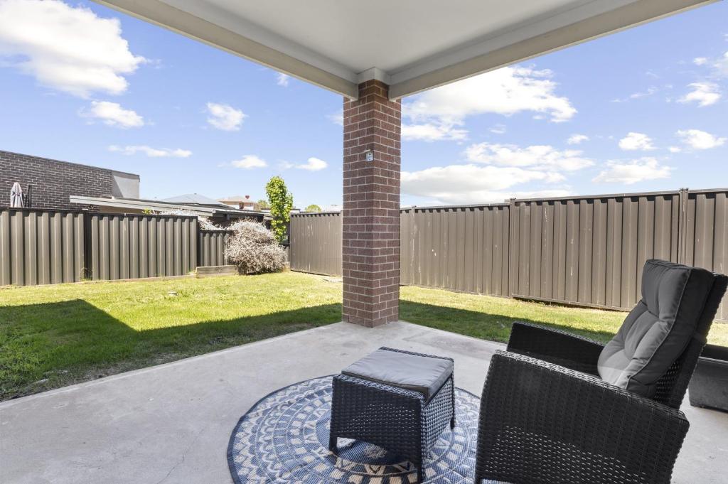 a patio with two chairs and a stool at Family Retreat with Garden and Parking in Melbourne