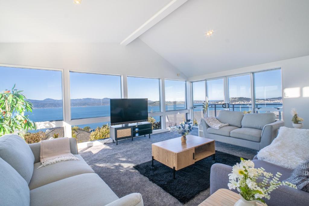 een woonkamer met banken en een flatscreen-tv bij Seaview Home in Khandallah in Wellington