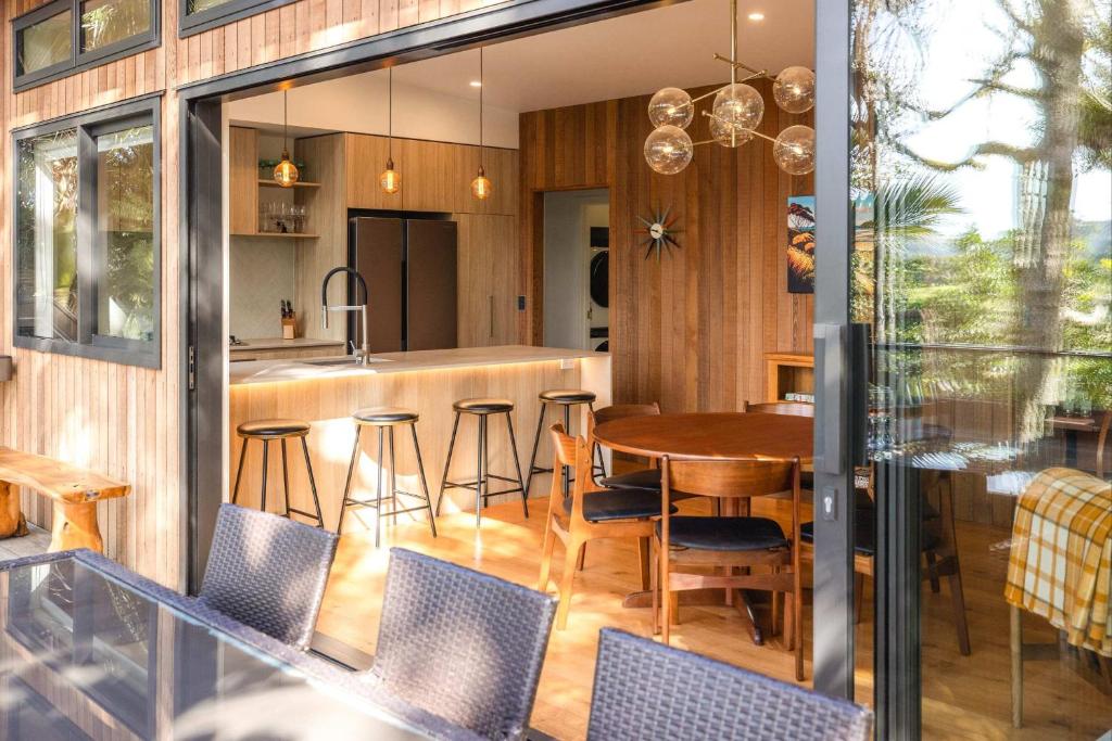 an open kitchen and dining room with a table and chairs at Te Toki Treehouse and Studio in Waiheke Island