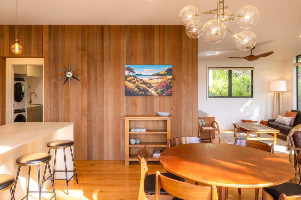 Waiheke IslandにあるTe Toki Treehouse and Studioのテーブルと椅子のあるダイニングルームとリビングルーム