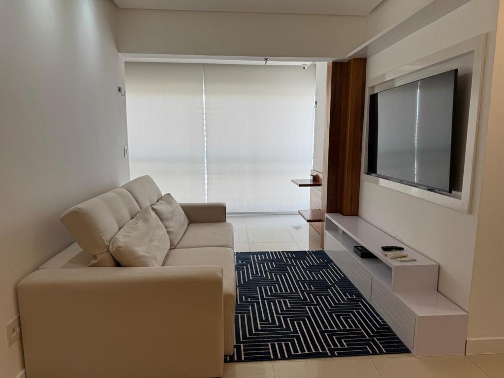 a living room with a couch and a flat screen tv at Alto padrão com ar, garagem, sacada integrada in Belém