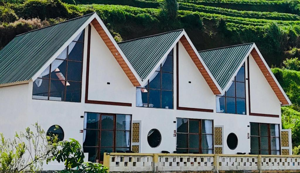 une maison avec un toit vert et des fenêtres dans l'établissement Arutala Villa tiitk 0 Dieng View Pegunungan, à Diyeng