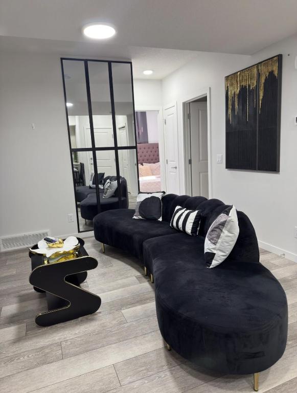a living room with a black couch and a table at Luxury Haven by Kc & Flo in YYC