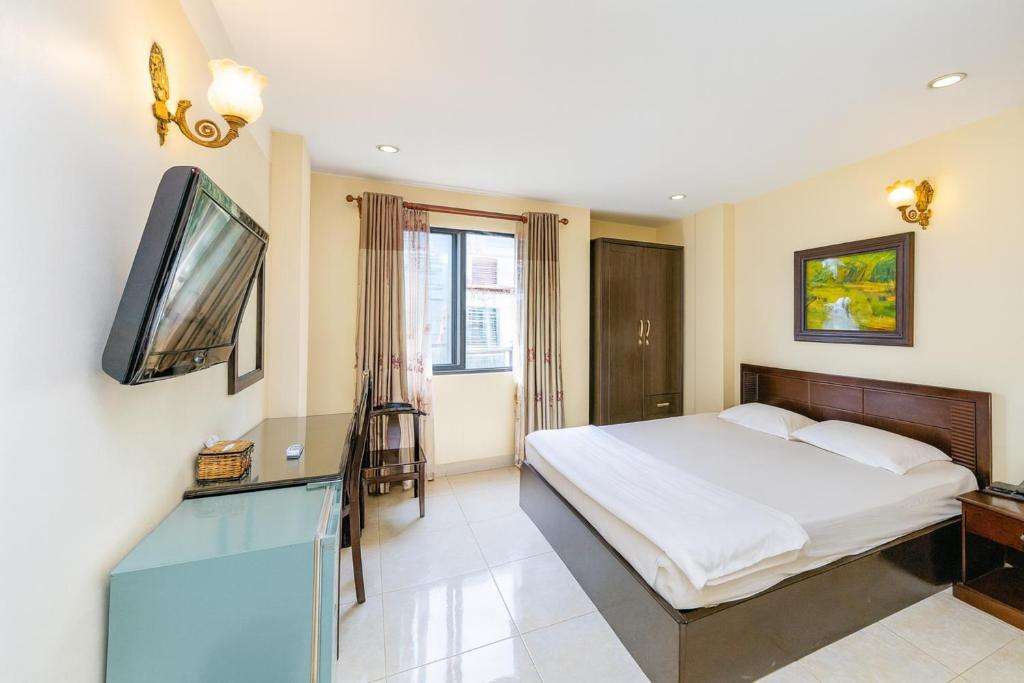 a bedroom with a bed and a flat screen tv at Cát Tường Hotel in Ho Chi Minh City